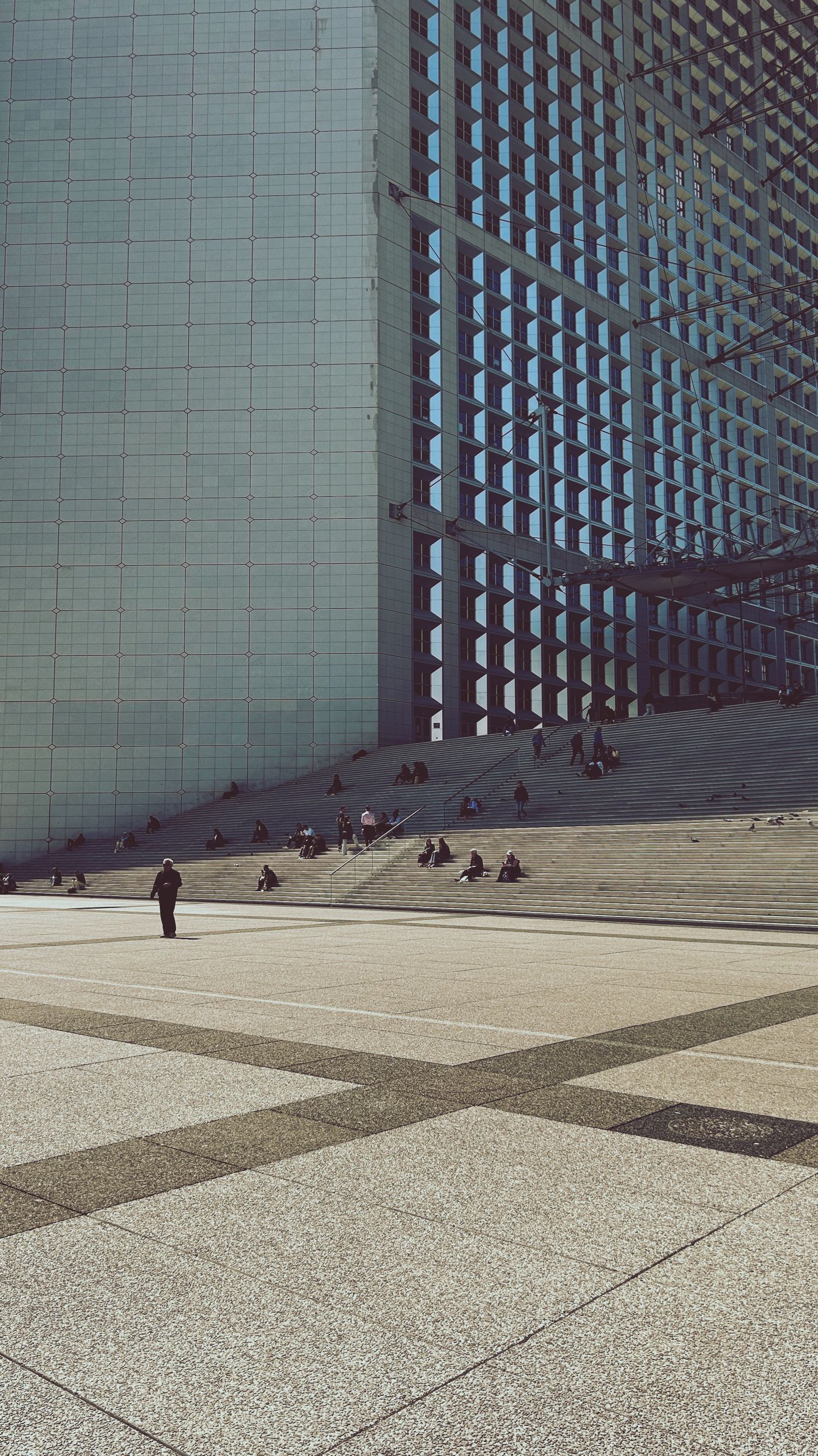 Parvis de La Défense, près de Paris, avec des passants au pied de la Grande Arche