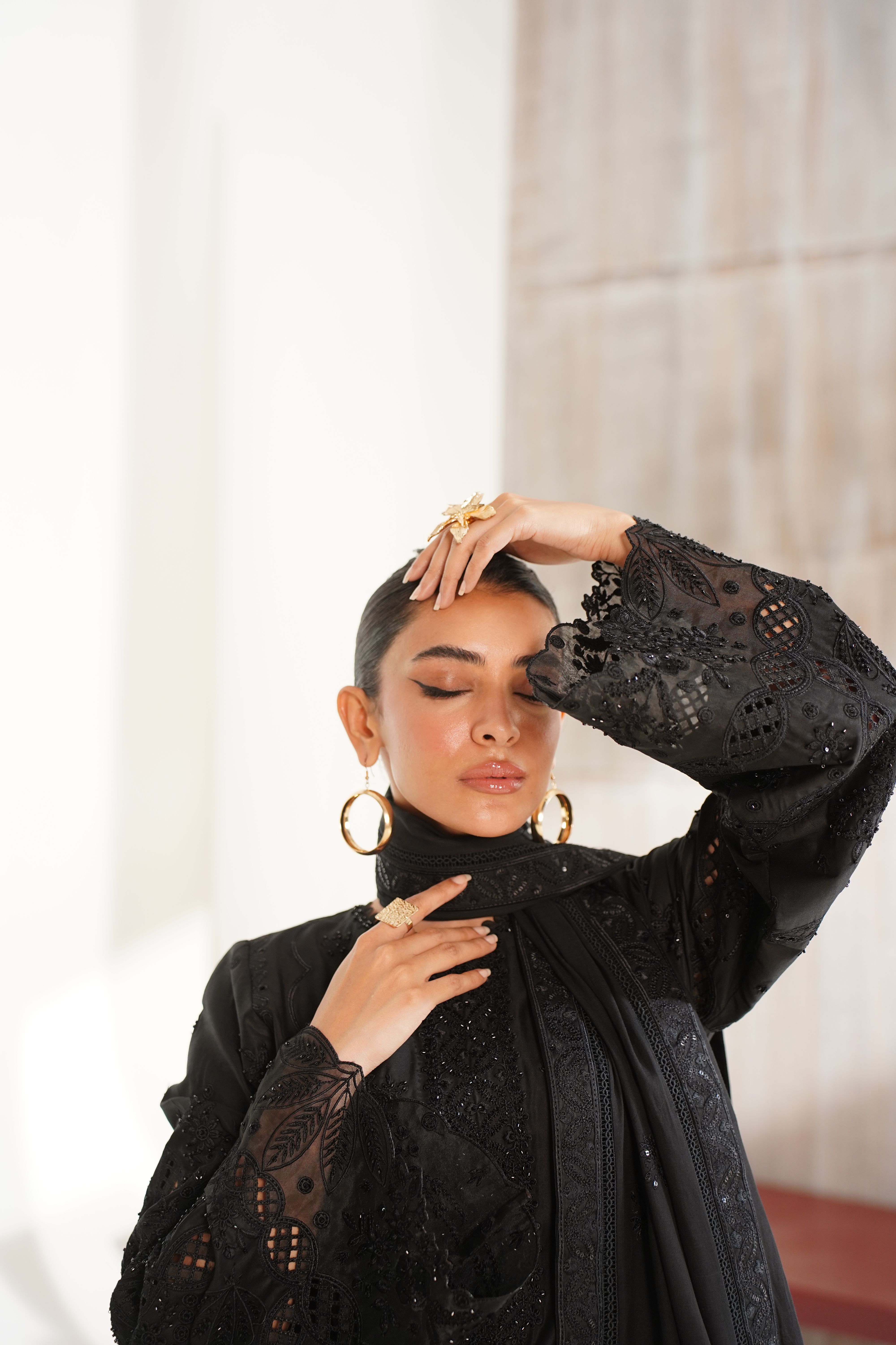 Stylish portrait of a woman in an embroidered black dress, captured in Lahore, Pakistan.