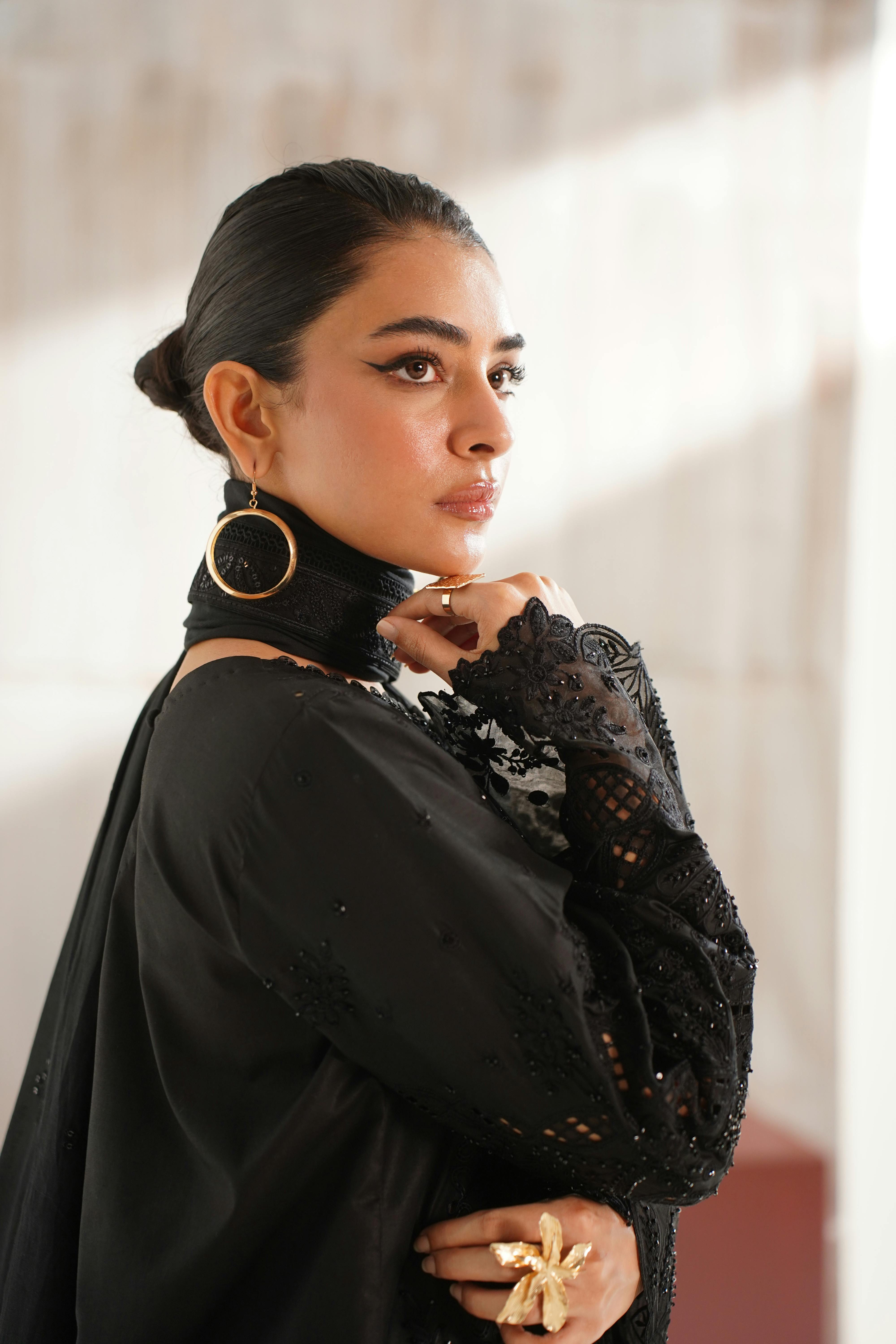 Stylish portrait of a model in black embroidered dress with statement jewelry, captured in Lahore.