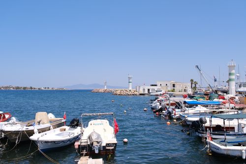 Free Beautiful coastal scene of Foça harbor in İzmir, Türkiye with fishing boats and clear blue skies. Stock Photo