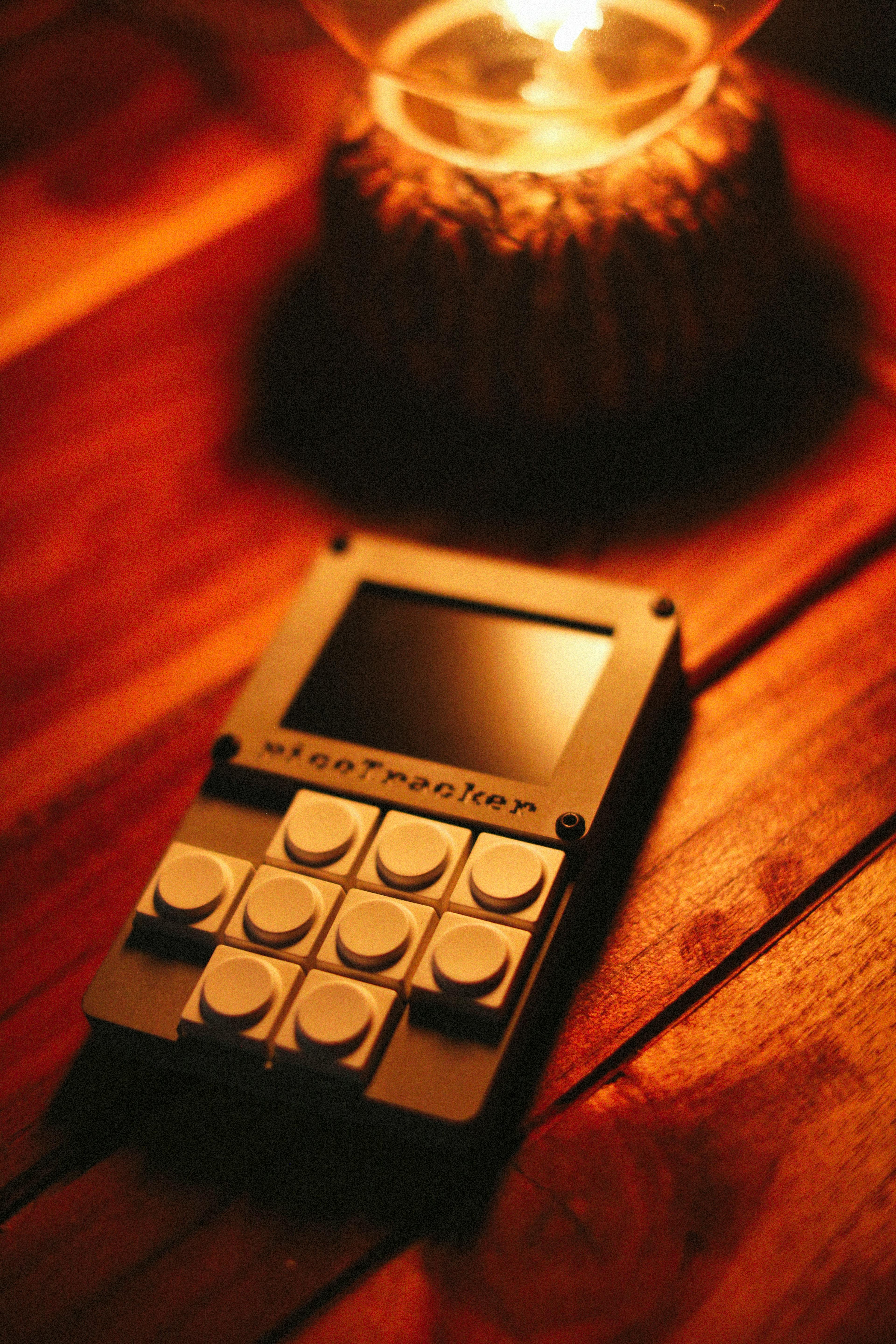 Warm-lit scene of a vintage electronic device on a rustic wooden table with a soft glowing lamp.