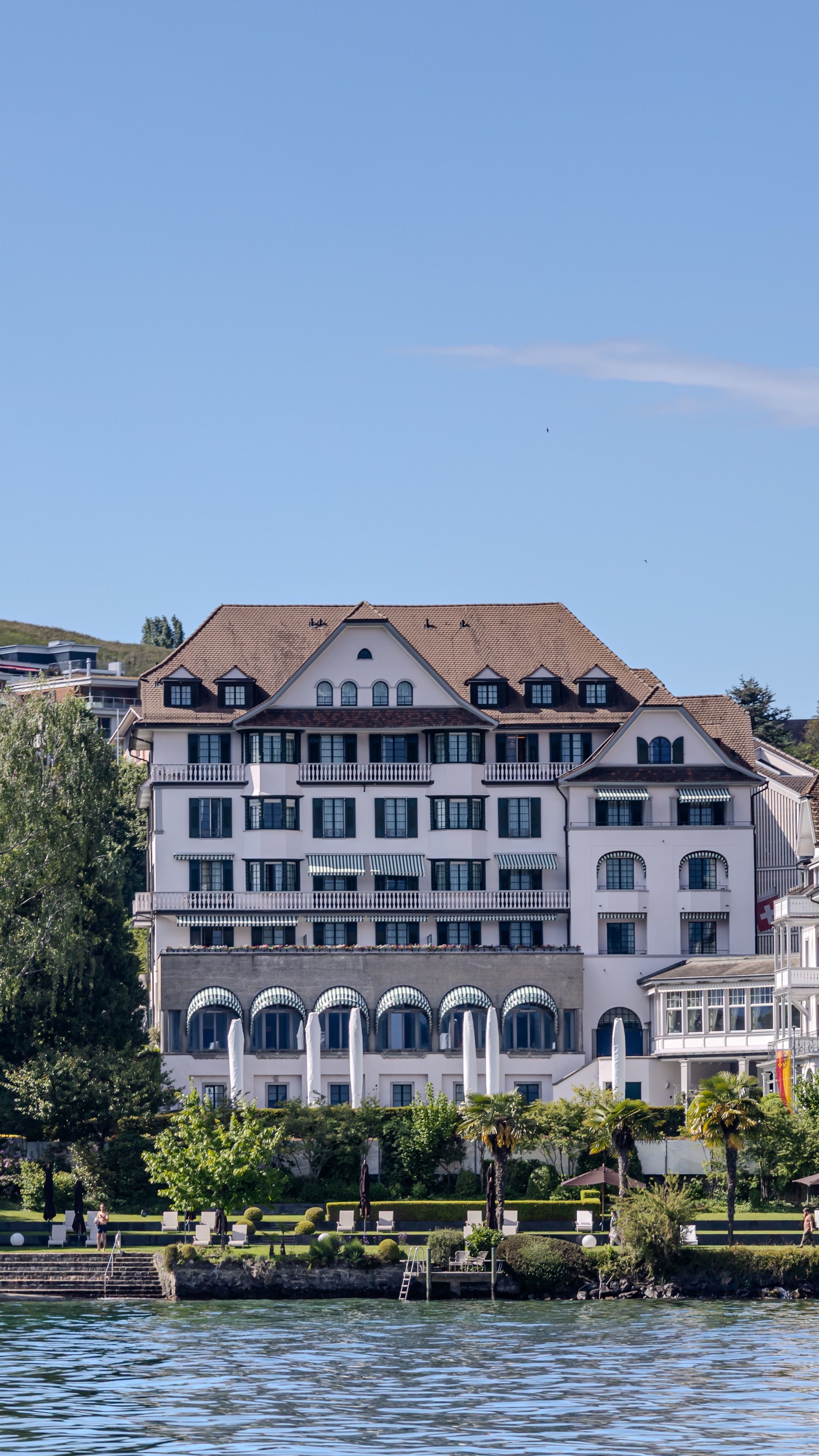 Elegant Lakeside Hotel Exterior with Scenic Views · Free Stock Photo