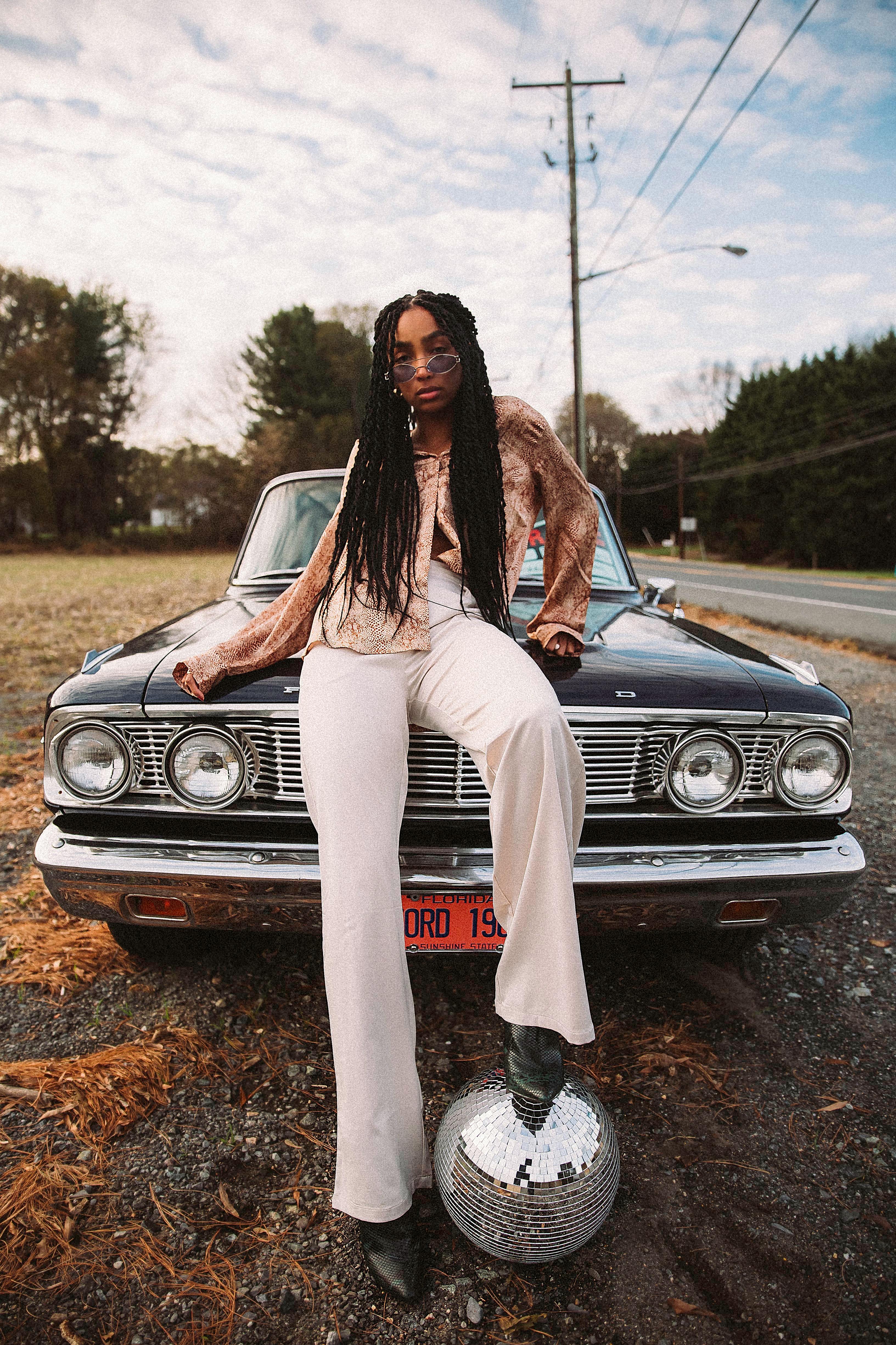 Woman Wearing Eyeglasses Sitting on Car