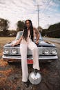一位留着辫子的时尚女子在户外老爷车旁摆出时尚的姿势