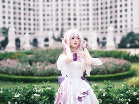 A captivating portrait of a cosplayer in a garden with an elegant backdrop.