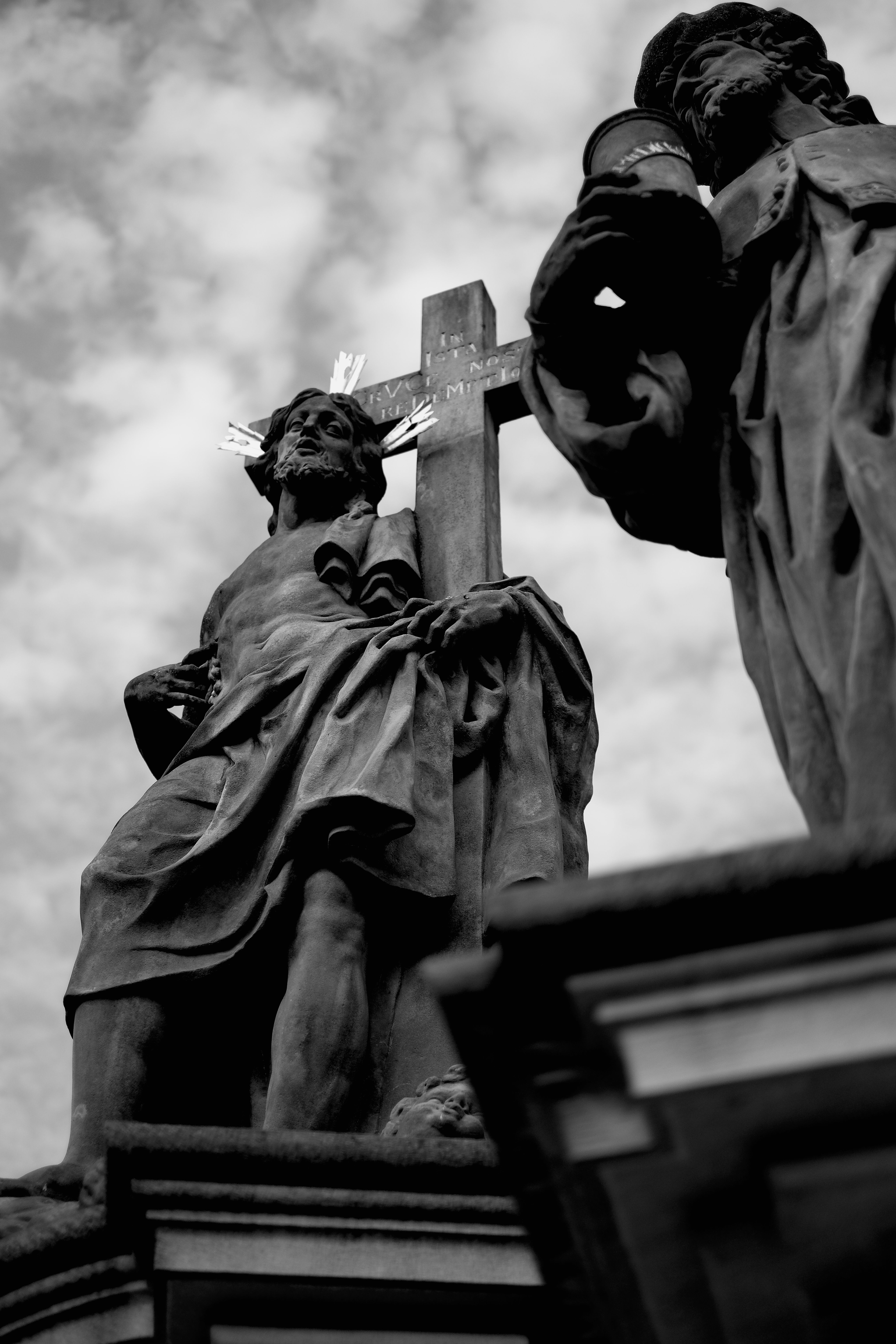 Historic religious statue with cross in black and white photography