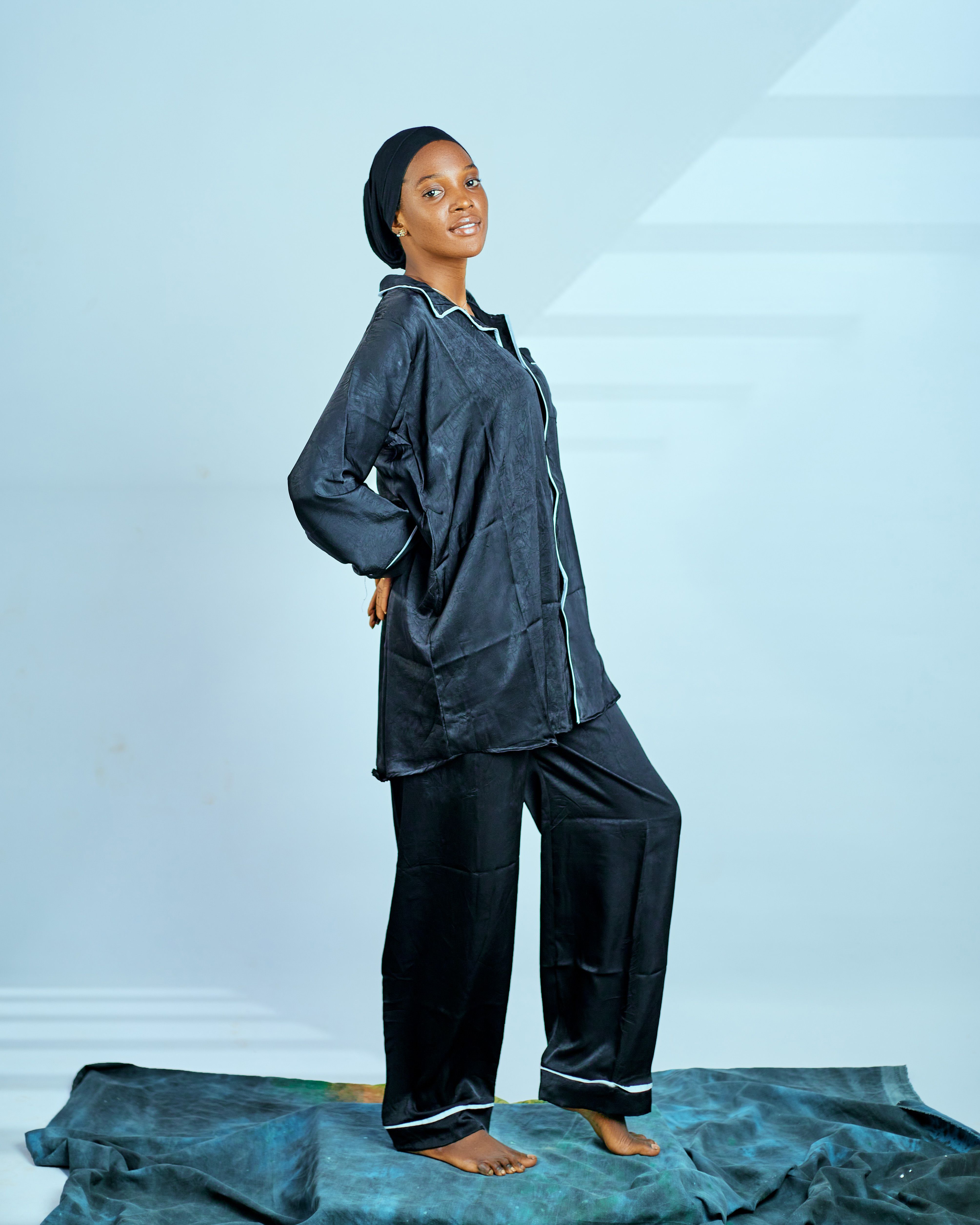Young woman in stylish black pajamas relaxing indoors