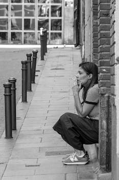 A woman in Madrid smoking on a sidewalk, showcasing urban lifestyle.