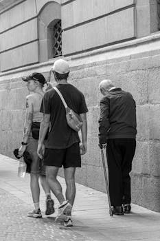 A black and white street photo of people walking in Madrid, capturing generational diversity and urban life.
