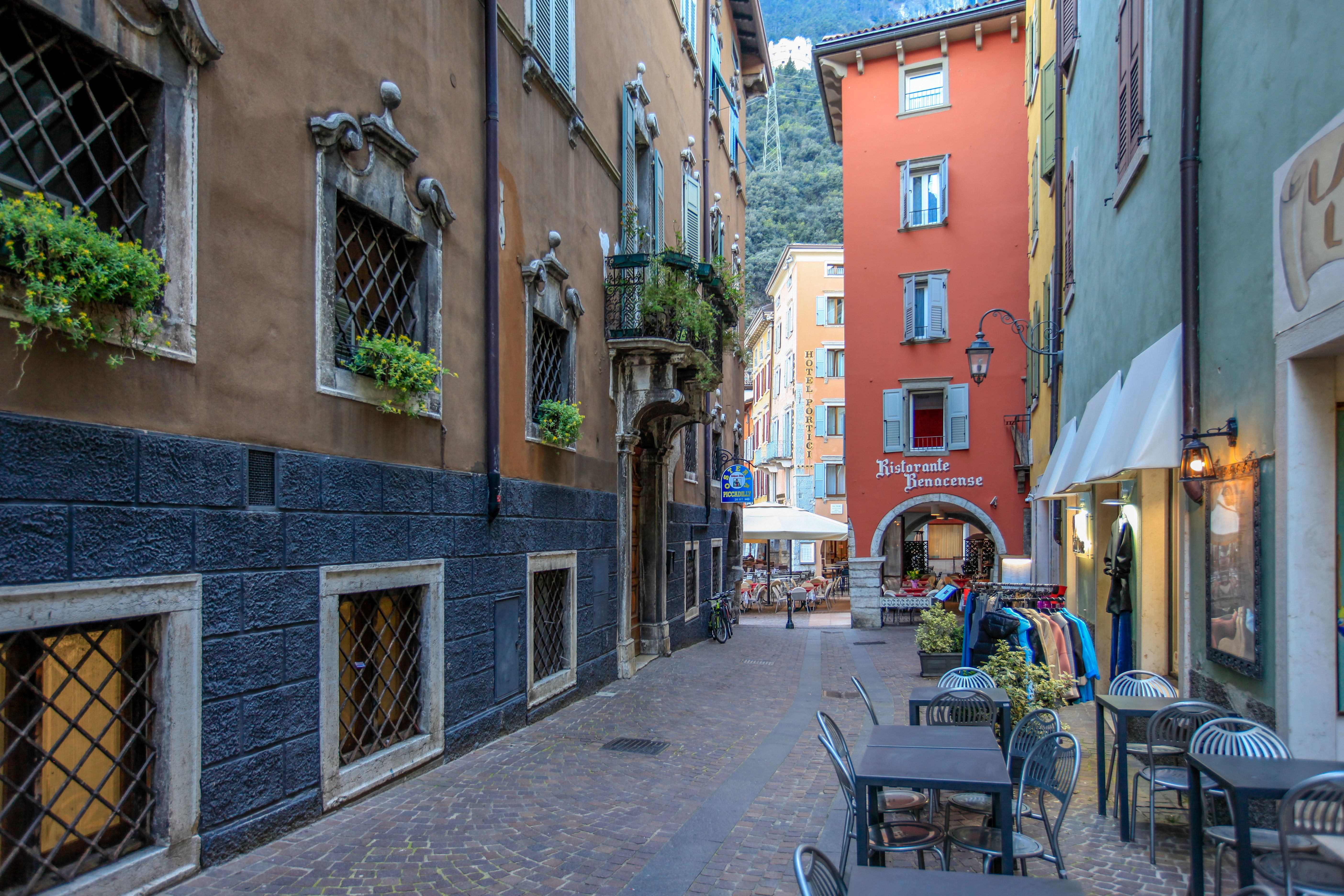 A quiet cobblestone street in an Eastern European city with colorful buildings, no crowds, and a local cafe with outdoor seating