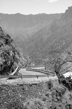 Black and white scenic view of a mountain road in La Palma, showcasing dramatic cliffs and curves.