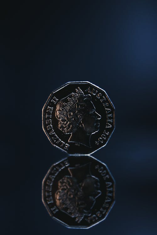 Reflection of old coin placed on blue background