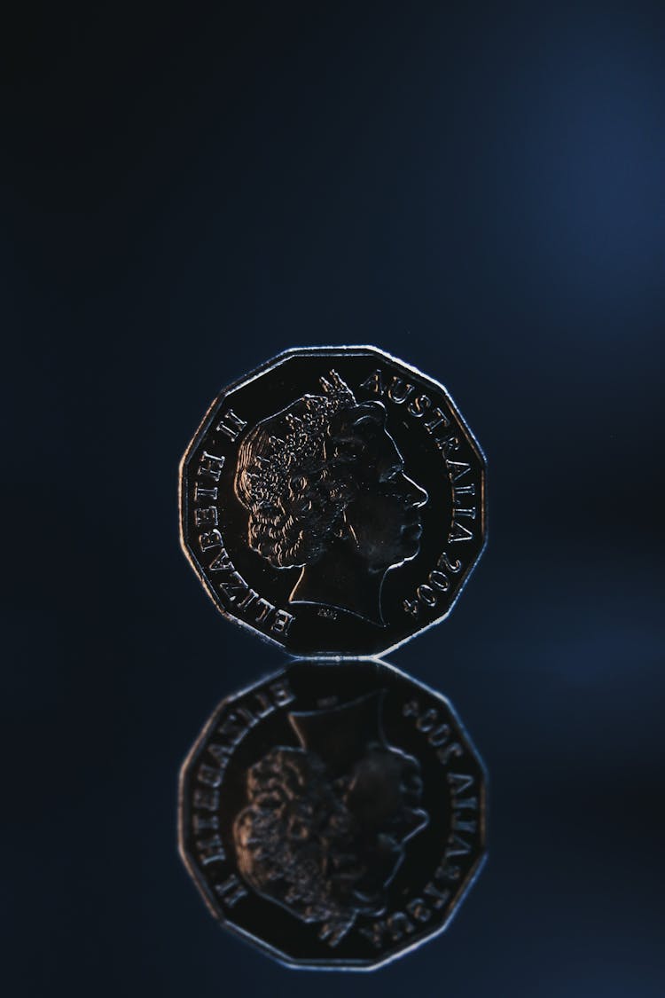 Reflection Of Old Coin Placed On Blue Background