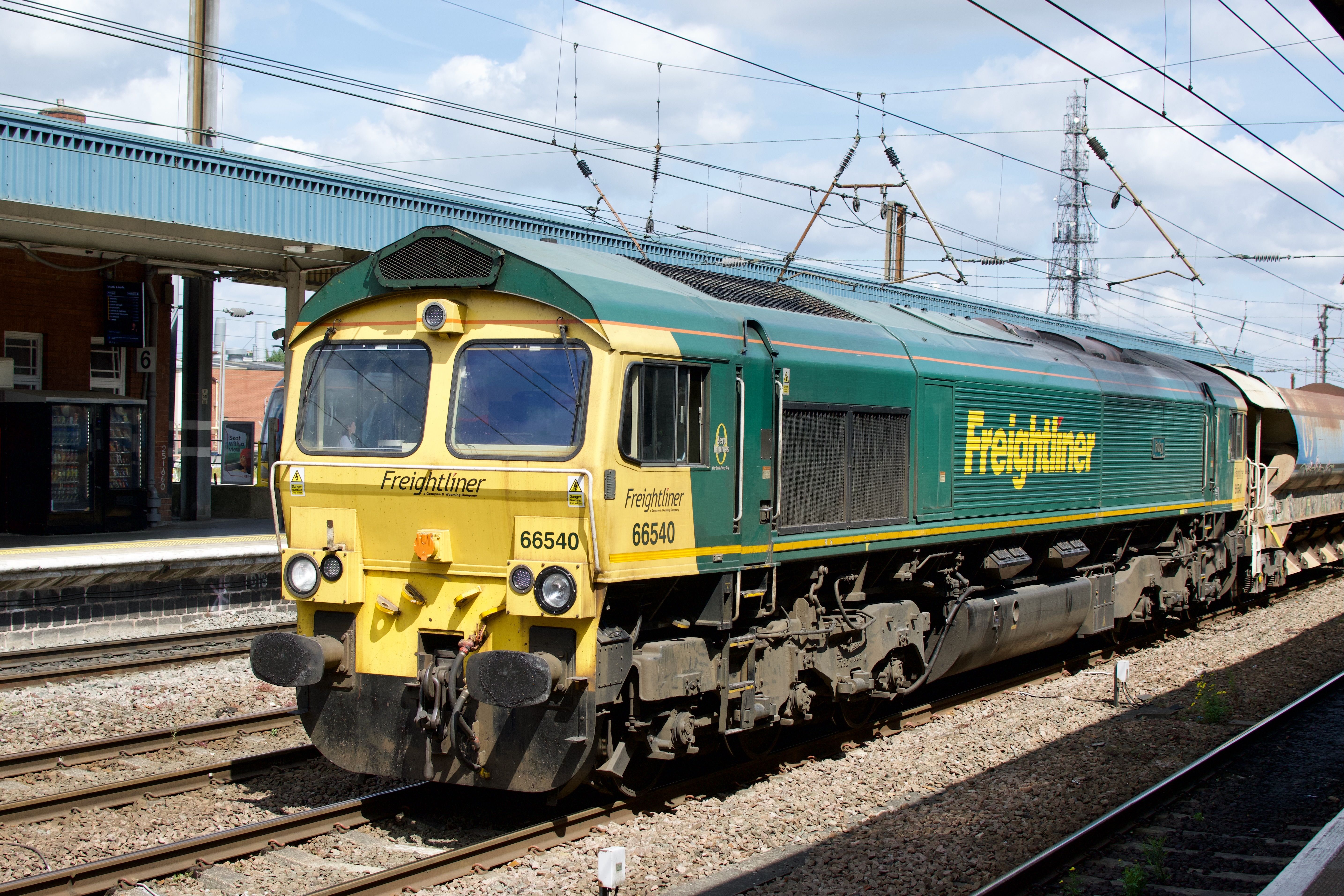 Freightliner locomotive at train station during daytime, showcasing modern rail transport.