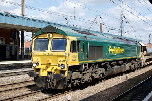 Freightliner locomotive at train station during daytime, showcasing modern rail transport.