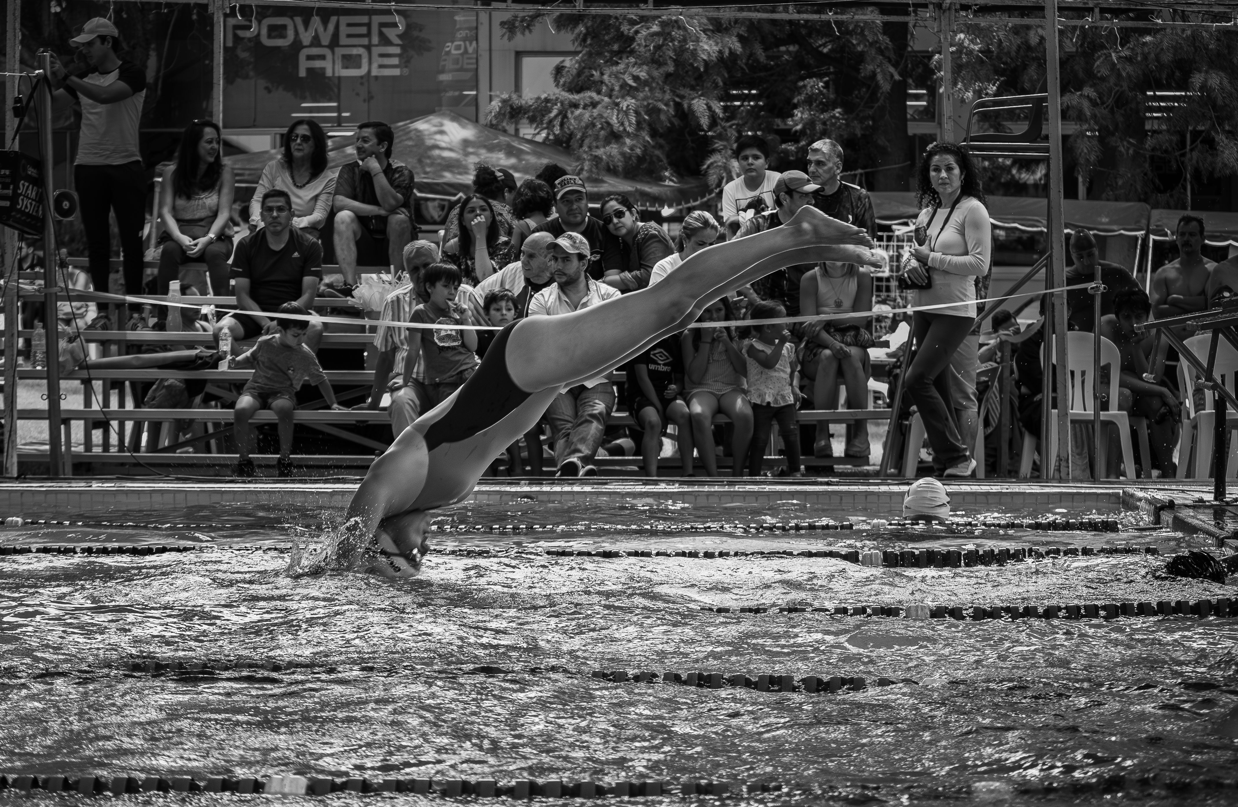 Un plongeur en plein saut dans les airs lors d'une compétition de natation.
