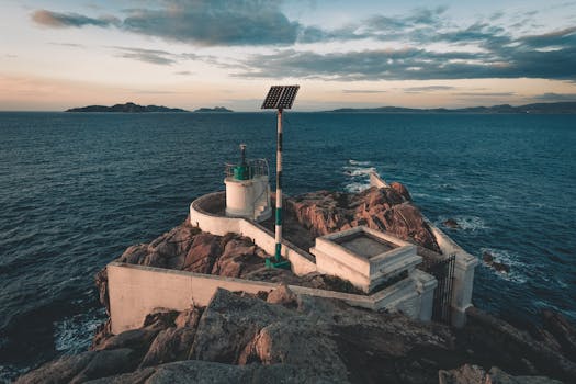 这座风景如画的灯塔矗立在岩石海岸线上，日落时分俯瞰大海，非常适合旅行或自然主题