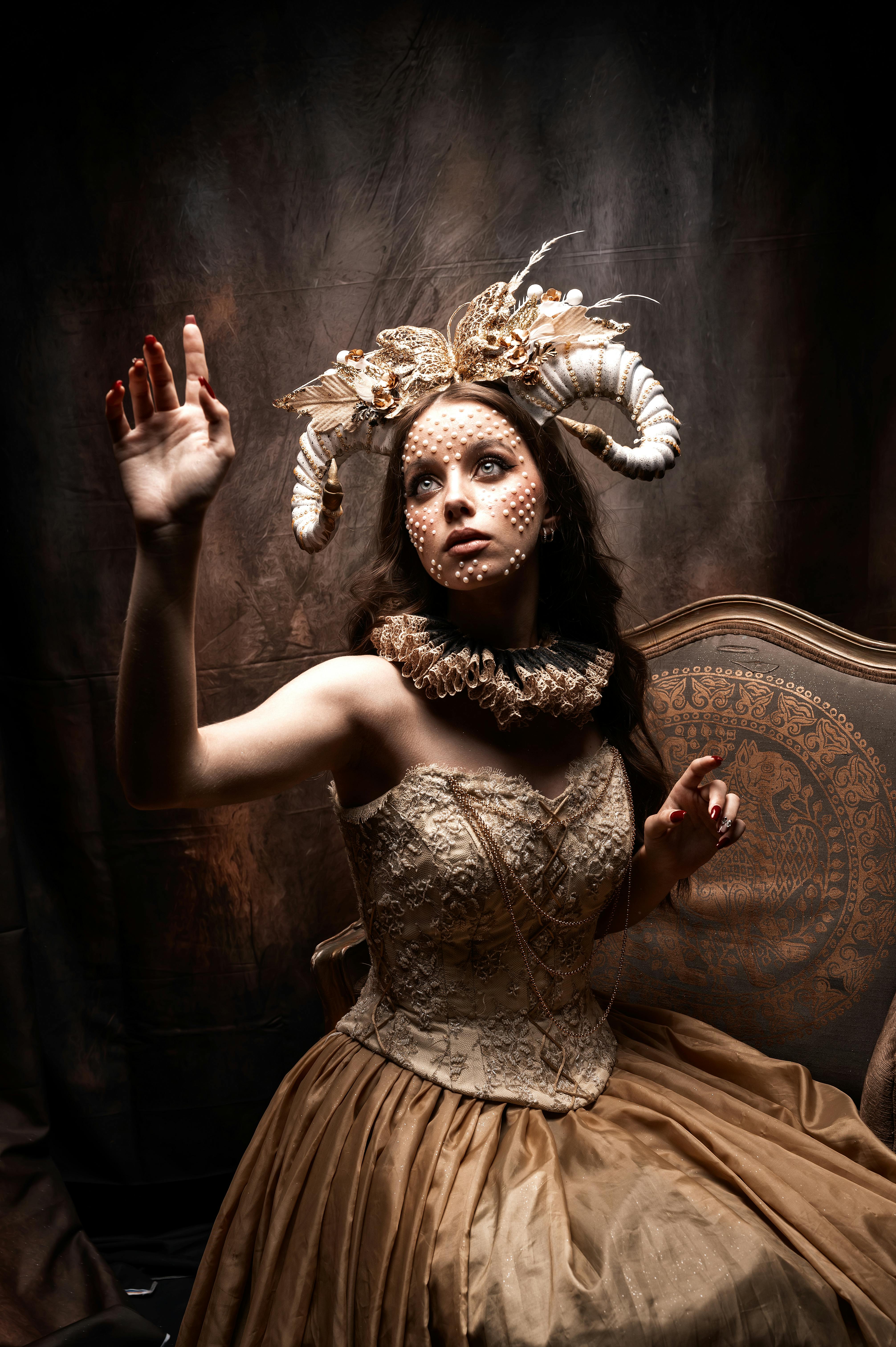 Gratuit Portrait artistique d'une femme en costume orné avec une coiffe en cornes de bélier, évoquant la fantaisie et la mythologie. Photos