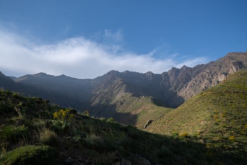 Free A tranquil mountain landscape with lush vegetation under a bright blue sky. Stock Photo