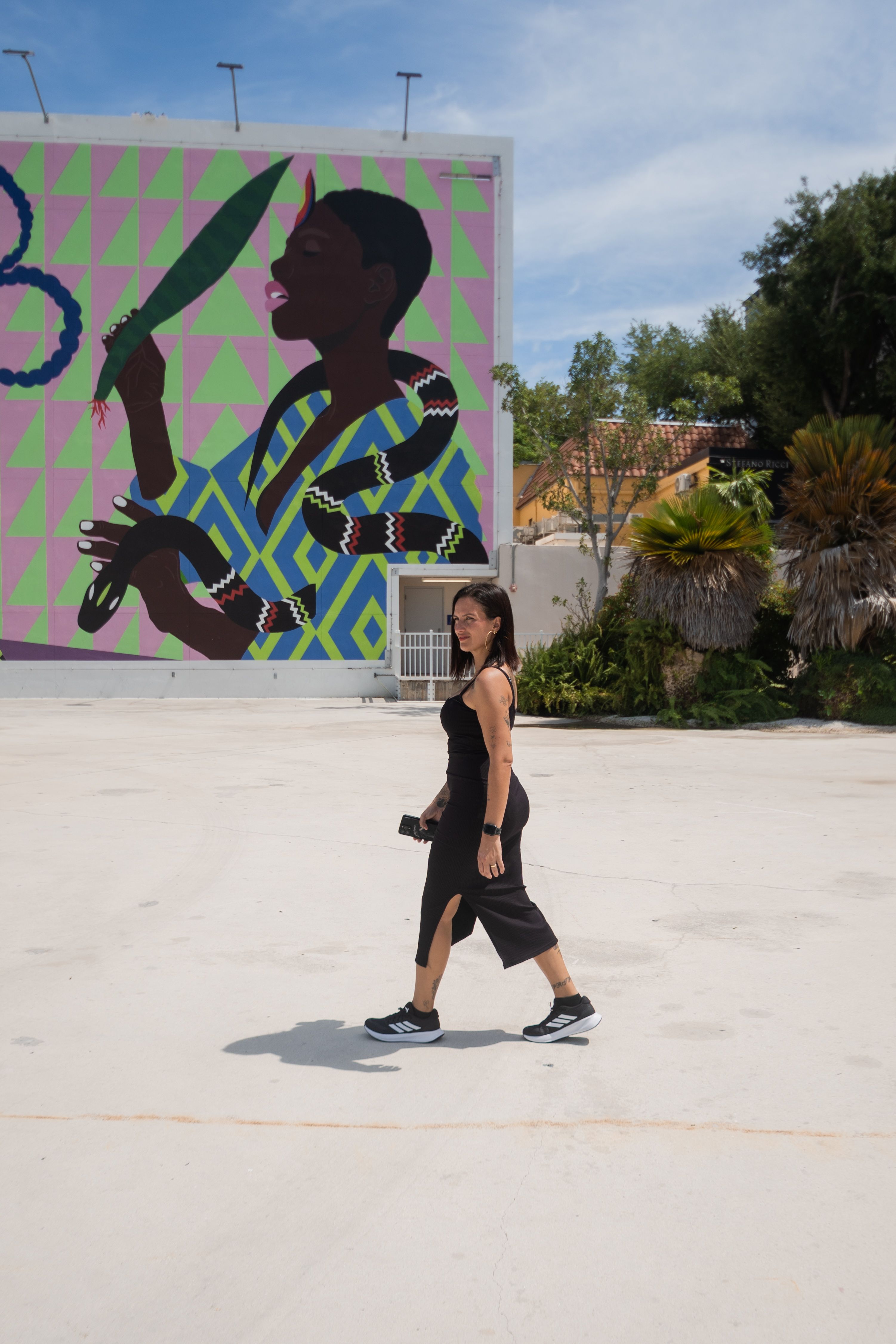 Woman Walking Past Vibrant Wall Mural Outdoors · Free Stock Photo