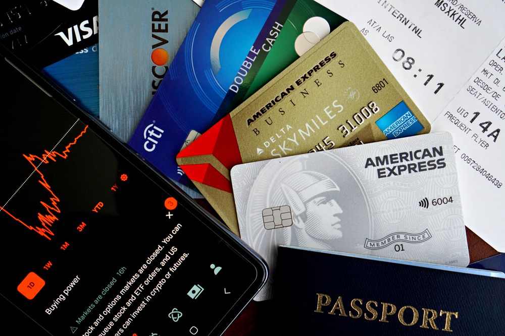 Cartões, passaporte e celular organizados sobre a mesa, planejamento de viagem