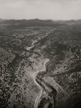 Black and white aerial shot of a winding road through a rugged Turkish landscape.