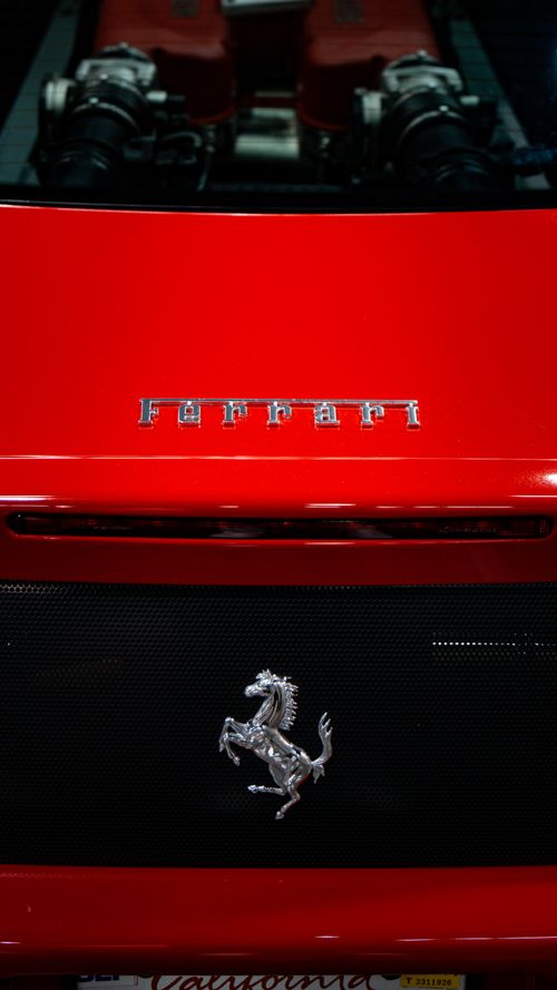 Free Close-up of a red sports car showcasing its iconic brand logo and sleek body design. Stock Photo