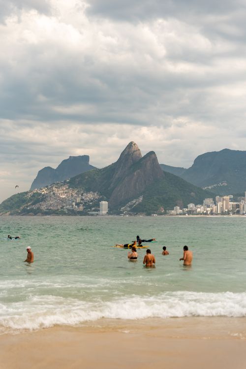 Free People enjoy the ocean at Ipanema Beach with stunning mountain views in Rio de Janeiro, Brazil. Stock Photo