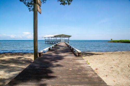 Free Wooden pier leading to a serene ocean view under a clear sky, ideal summer day. Stock Photo