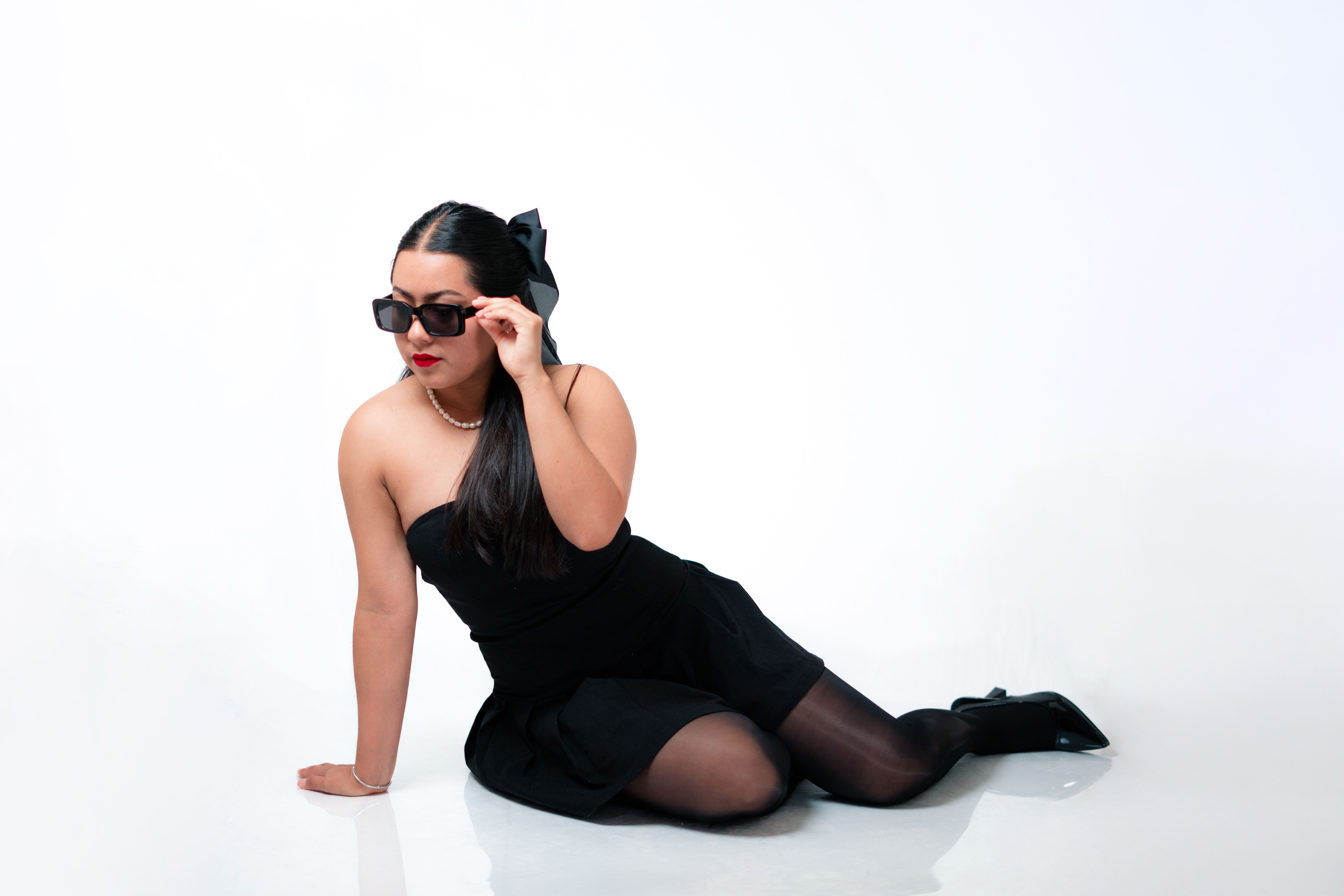 Female Model Wearing a Black Dress Posing in a Studio · Free Stock Photo