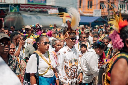 Colorful festival parade featuring participants in traditional attire and headpieces.