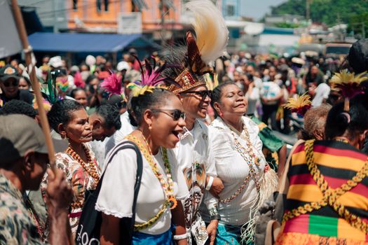 Joyful parade of people in vibrant cultural costumes celebrating outdoors.