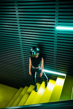 A person in sports attire and helmet stands on neon yellow stairs indoors, creating a futuristic vibe.