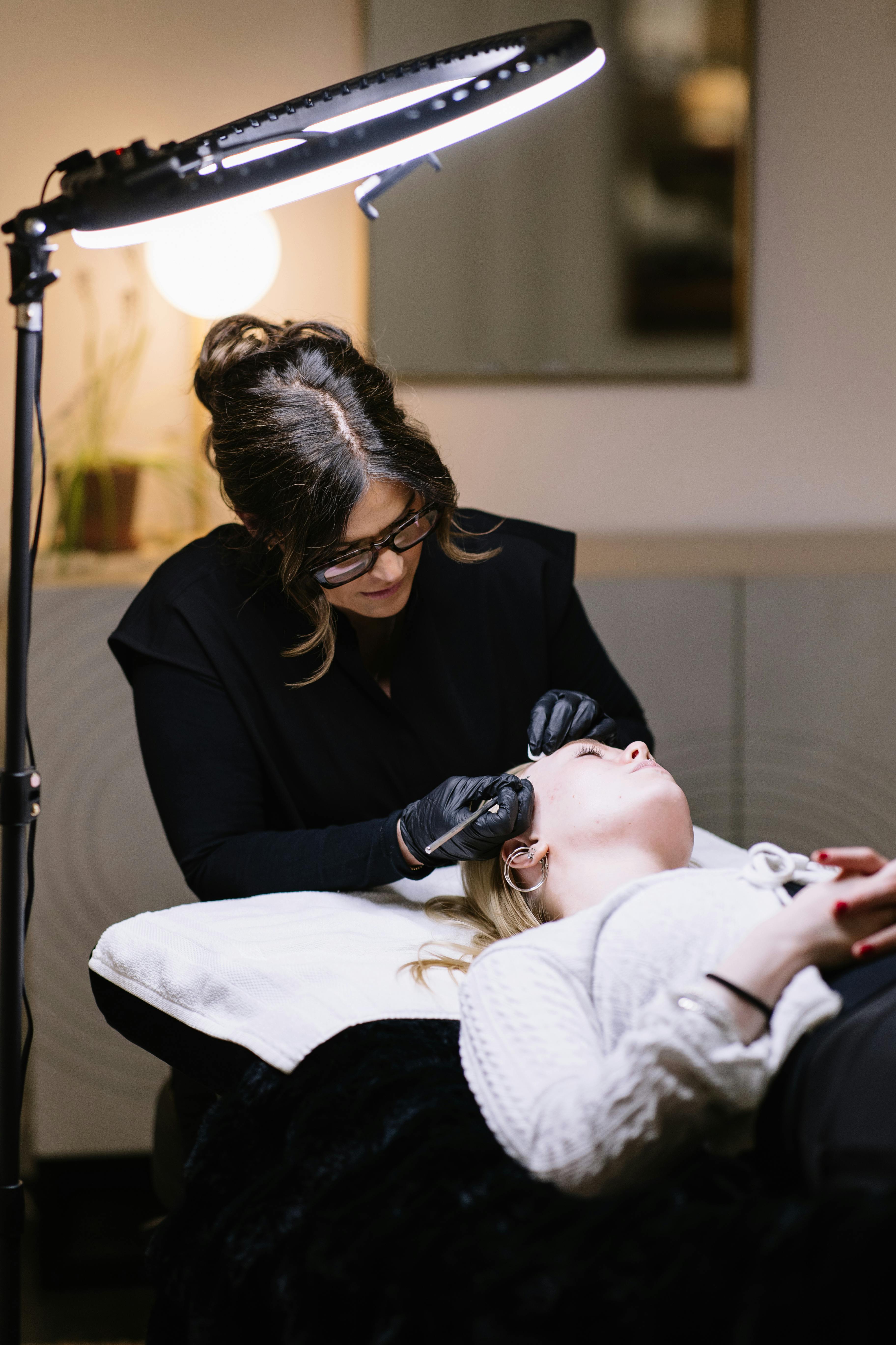 Esthetician performing professional skincare treatment in a salon setting.