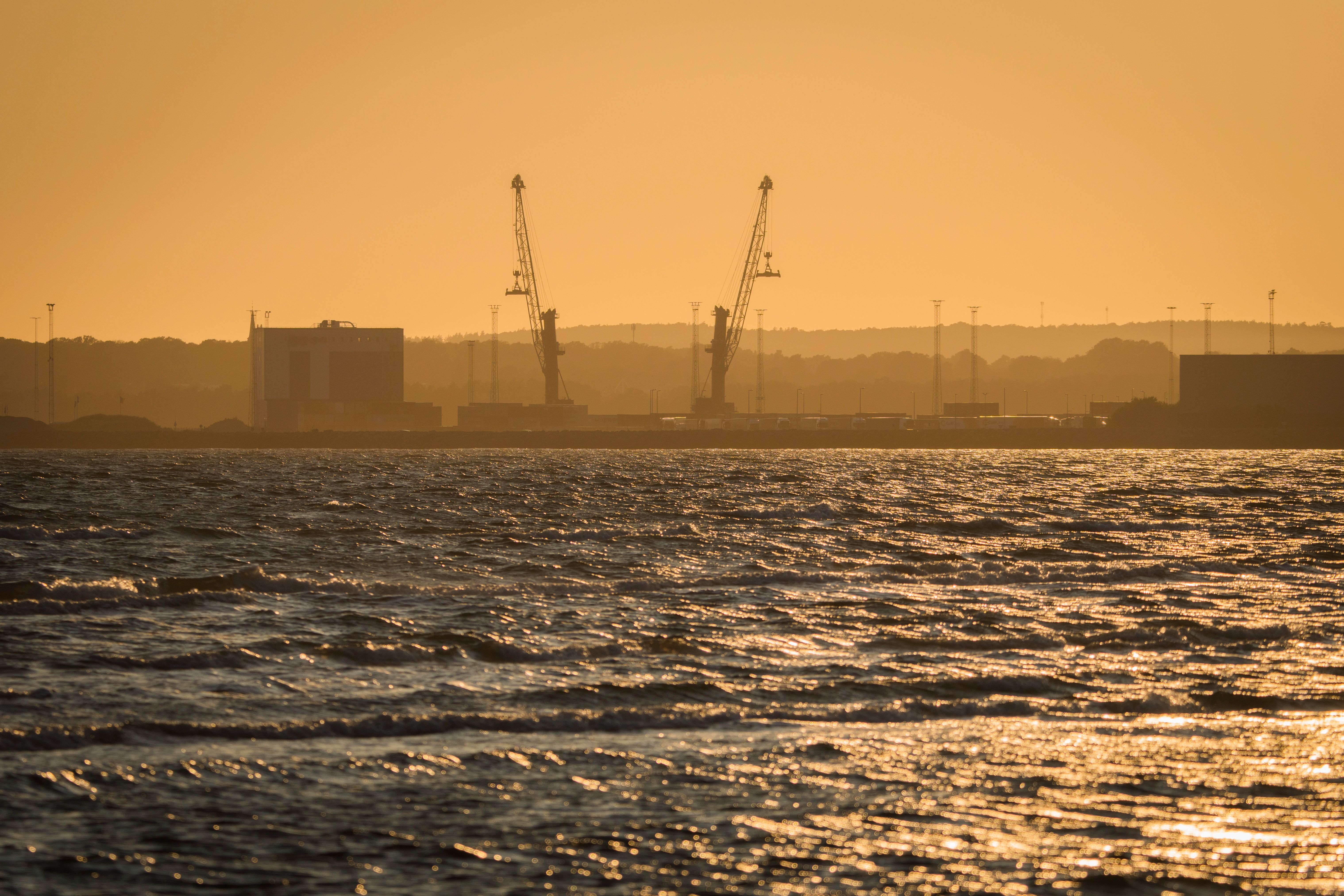 A ferry crossing the harbour towards Vypin island with cranes on the horizon