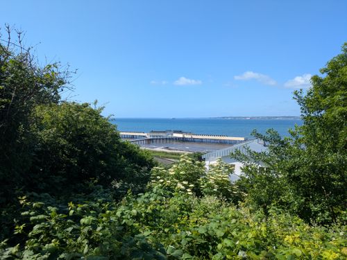 Free Scenic view of a coastal landscape with lush greenery and clear blue sea under a bright sky. Stock Photo