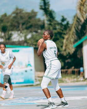 A young athlete prepares to shoot the basketball on an outdoor court during a game.