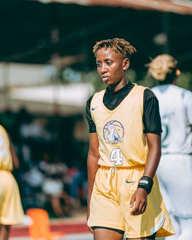 Teen basketball player in action during an outdoor game, showing determination.