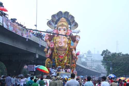 Free Crowds celebrate with a massive Ganesh statue during a vibrant street festival in India. Stock Photo
