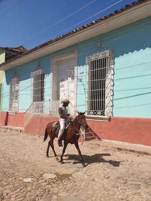 Photo of a Man Riding a Brown Horse