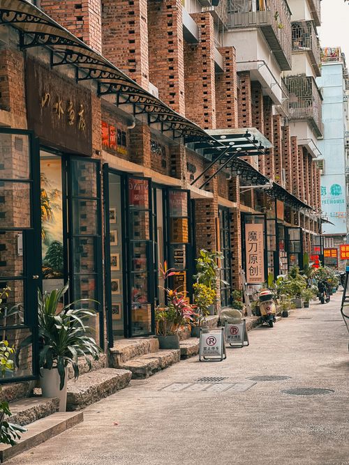 Free A cozy urban alley lined with rustic brick shops and green plants, perfect for exploring. Stock Photo