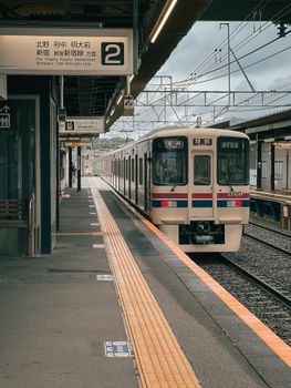 A Japanese train at a station, ready to depart. Urban transport imagery.