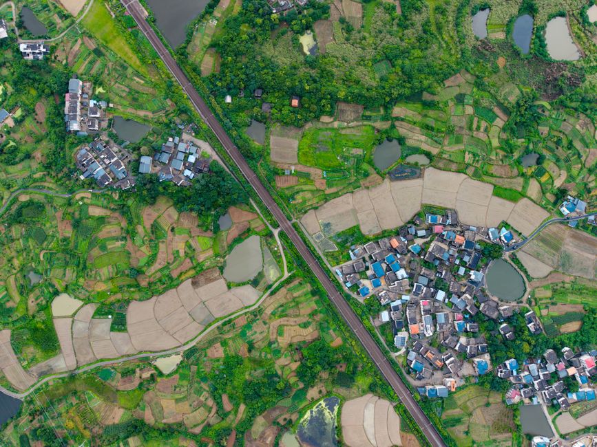 Unforgettable Yangshuo Helicopter Tour from Yangshuo Hotel Review: Soaring Over China's Most Spectacular Karst Landscape Review 2026 - A stunning aerial shot showcasing vibrant green rice terraces and small villages in China.