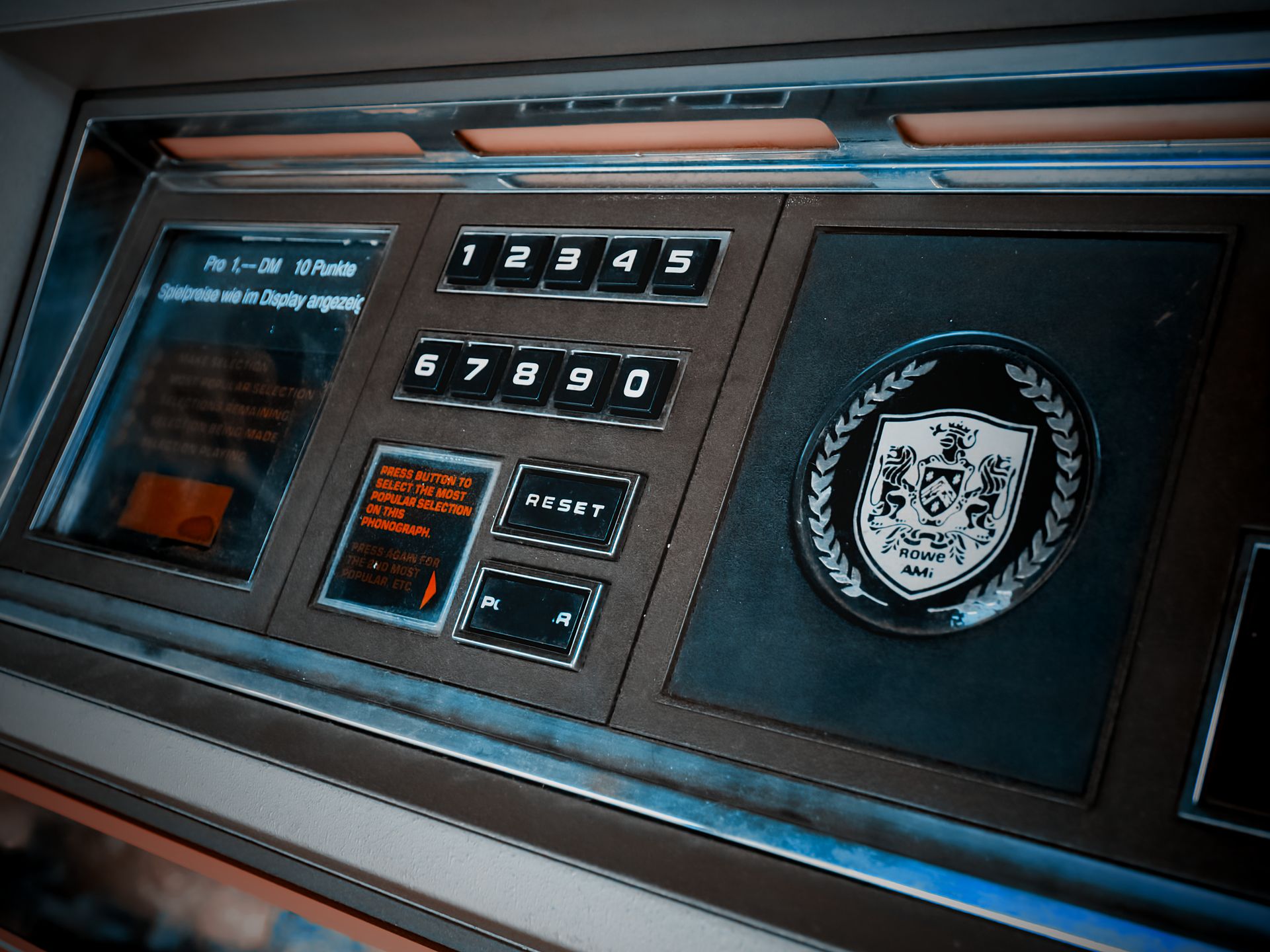 Close-up of a vintage arcade machine control panel with numeric keypad and emblem.