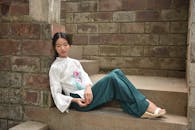 Stylish Woman Relaxing on Rustic Stone Steps
