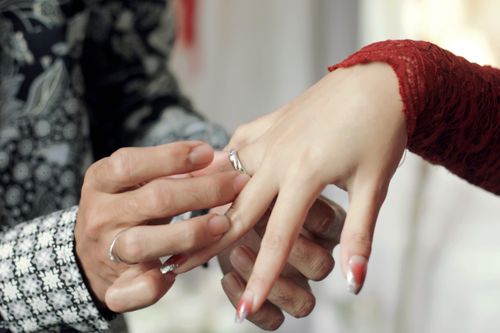 Free Close-up of hands during an engagement ring exchange ceremony showcasing intricate designs. Stock Photo