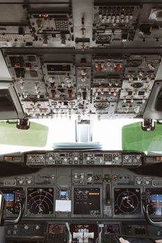 Panoramic view inside an airplane cockpit showcasing controls and instruments during daylight.