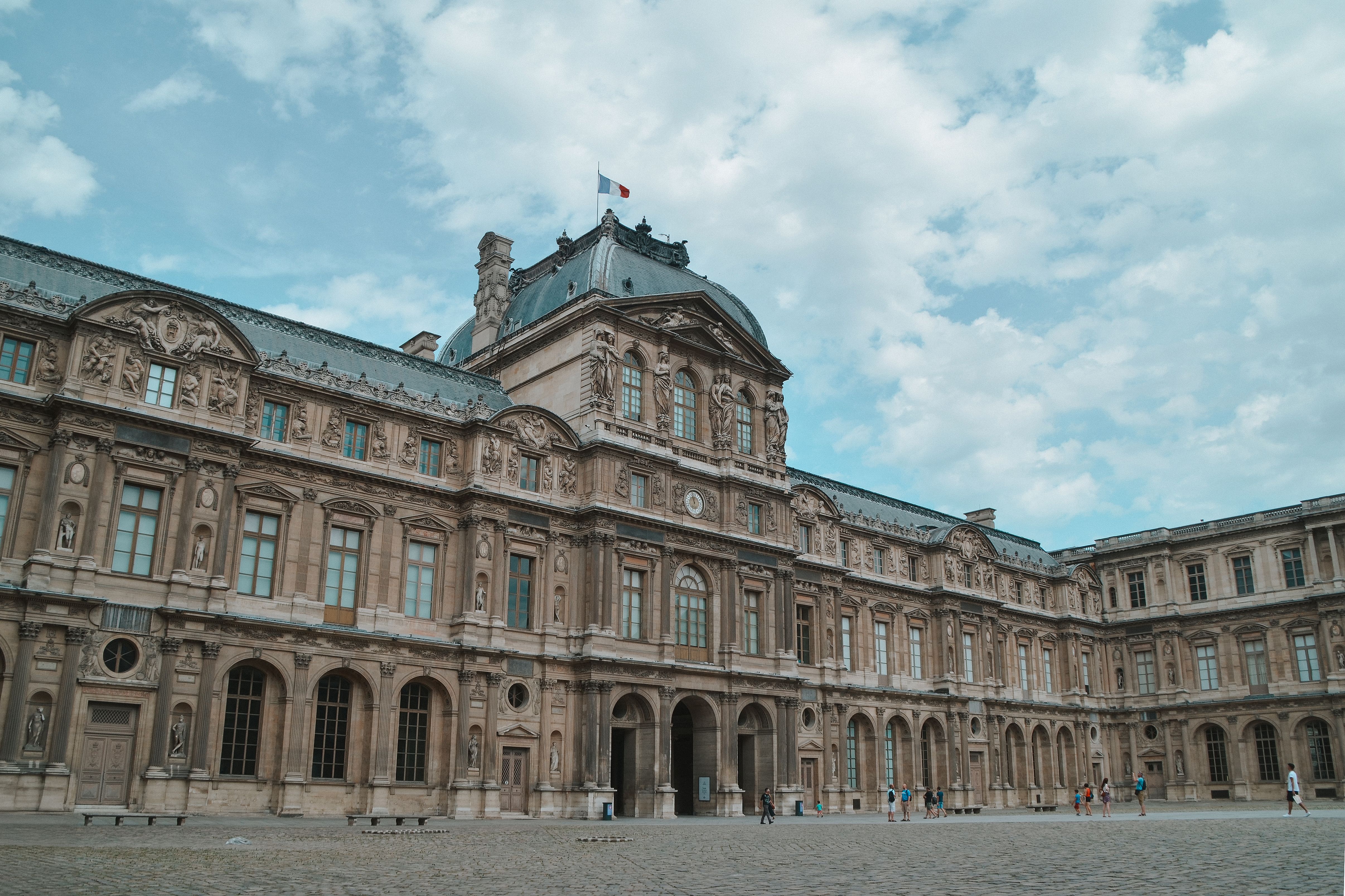 Facade of the Louvre Museum in Paris, showcasing stunning architecture under a bright sky. Facade of the Louvre Museum in Paris, showcasing stunning architecture under a bright sky.