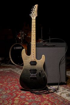 Electric guitar placed in a studio with an amplifier, ready for a musical performance.