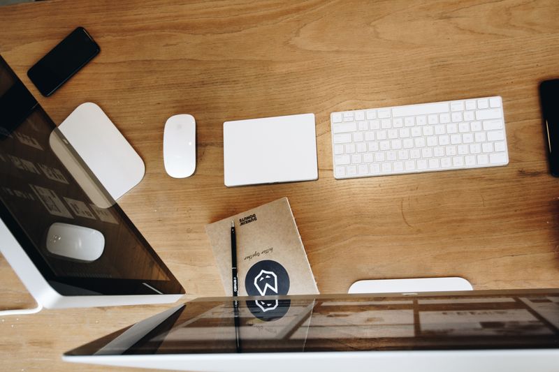 white desk with white monitor stand and white storage boxes